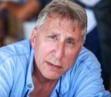 Image showing Dr. Federici wearing a blue collared shirt, leaning in towards the camera as if listening intently.